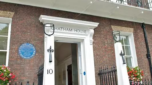 Photograph of the Chatham House depicting the main entrance and part of the first floor balcony, with the Chatham House's flag