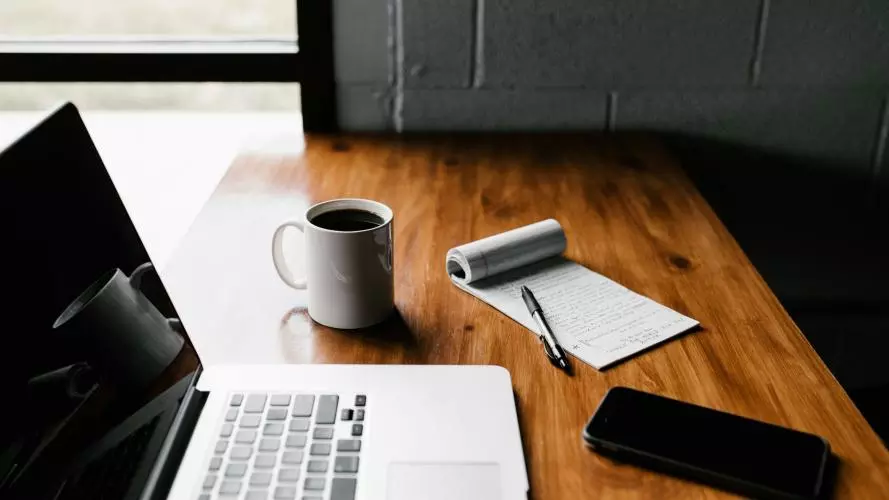 laptop on a table with a coffee