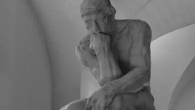 black and white photo of a statue of a man thinking