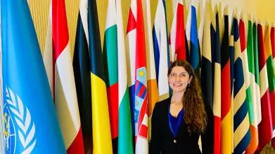 Denise Kohlhepp in front of UN flags.