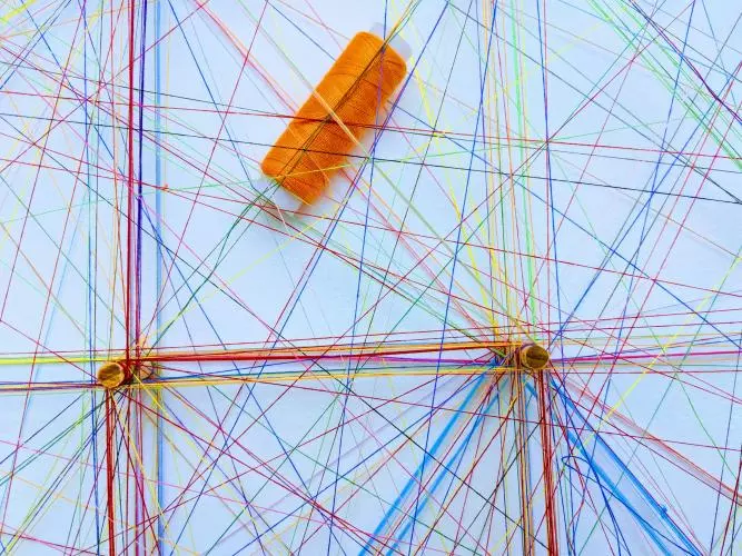 Assorted sewing threads of many different colours forming webs/networks. 