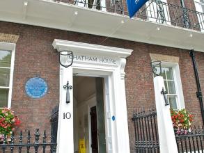 Photograph of the Chatham House depicting the main entrance and part of the first floor balcony, with the Chatham House's flag