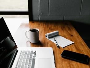 laptop on a table with a coffee