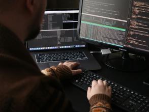 A man sitting in front of a computer on a desk