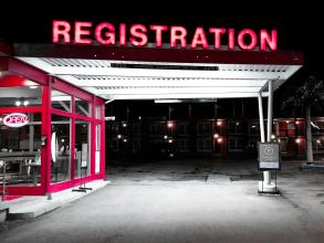 Neon sign at a petrol station saying "registration"