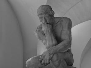 black and white photo of a statue of a man thinking
