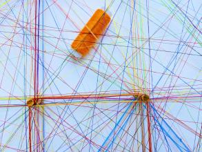 Assorted sewing threads of many different colours forming webs/networks. 