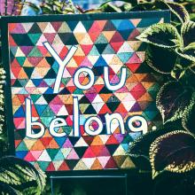 Mural painting with writing "You Belong" surrounded  by plants.