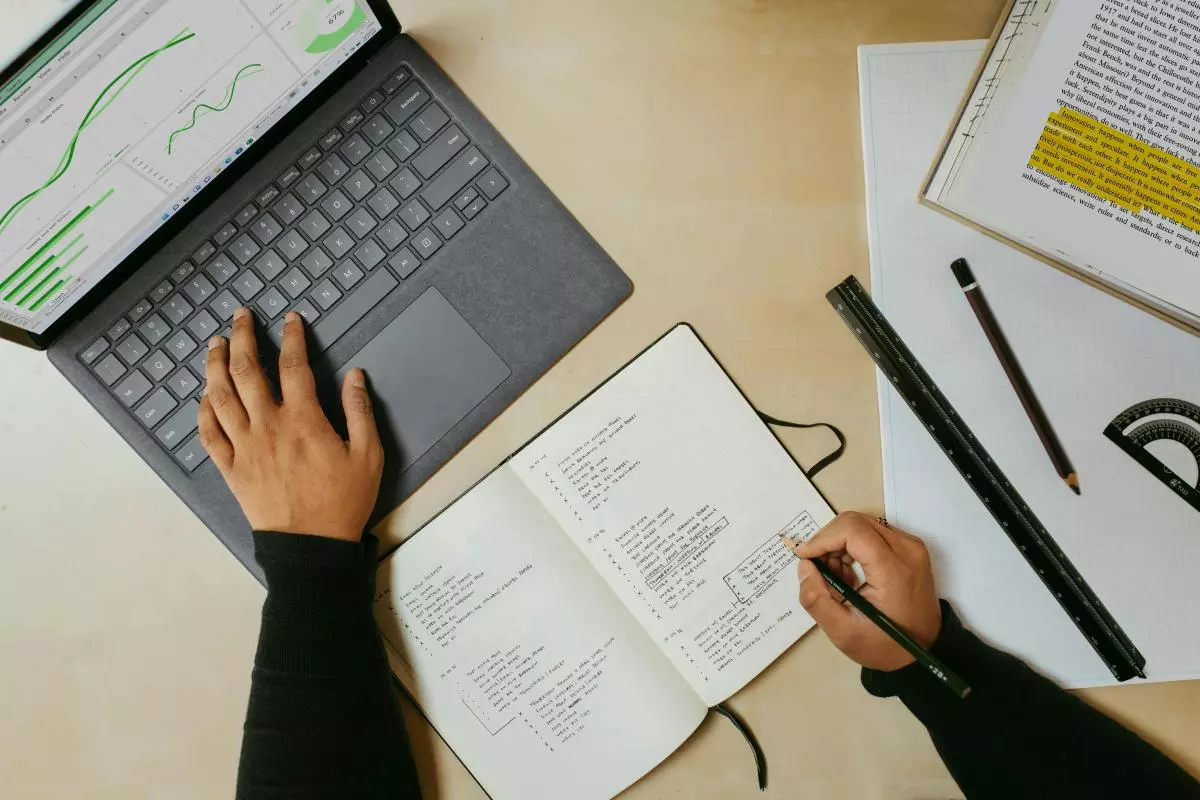laptop and notebook with notes 