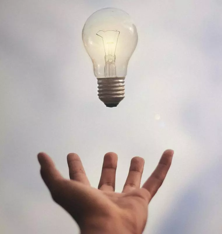 Person catching light bulb